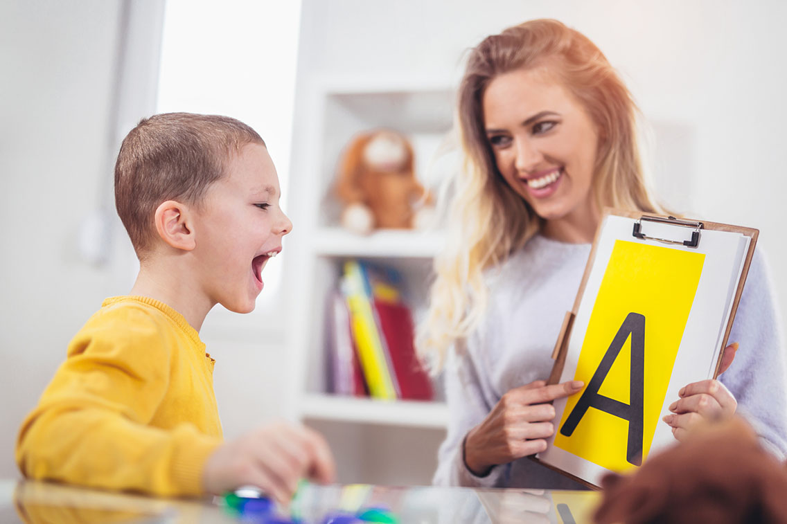 Boy in ABA therapy learning to say letters