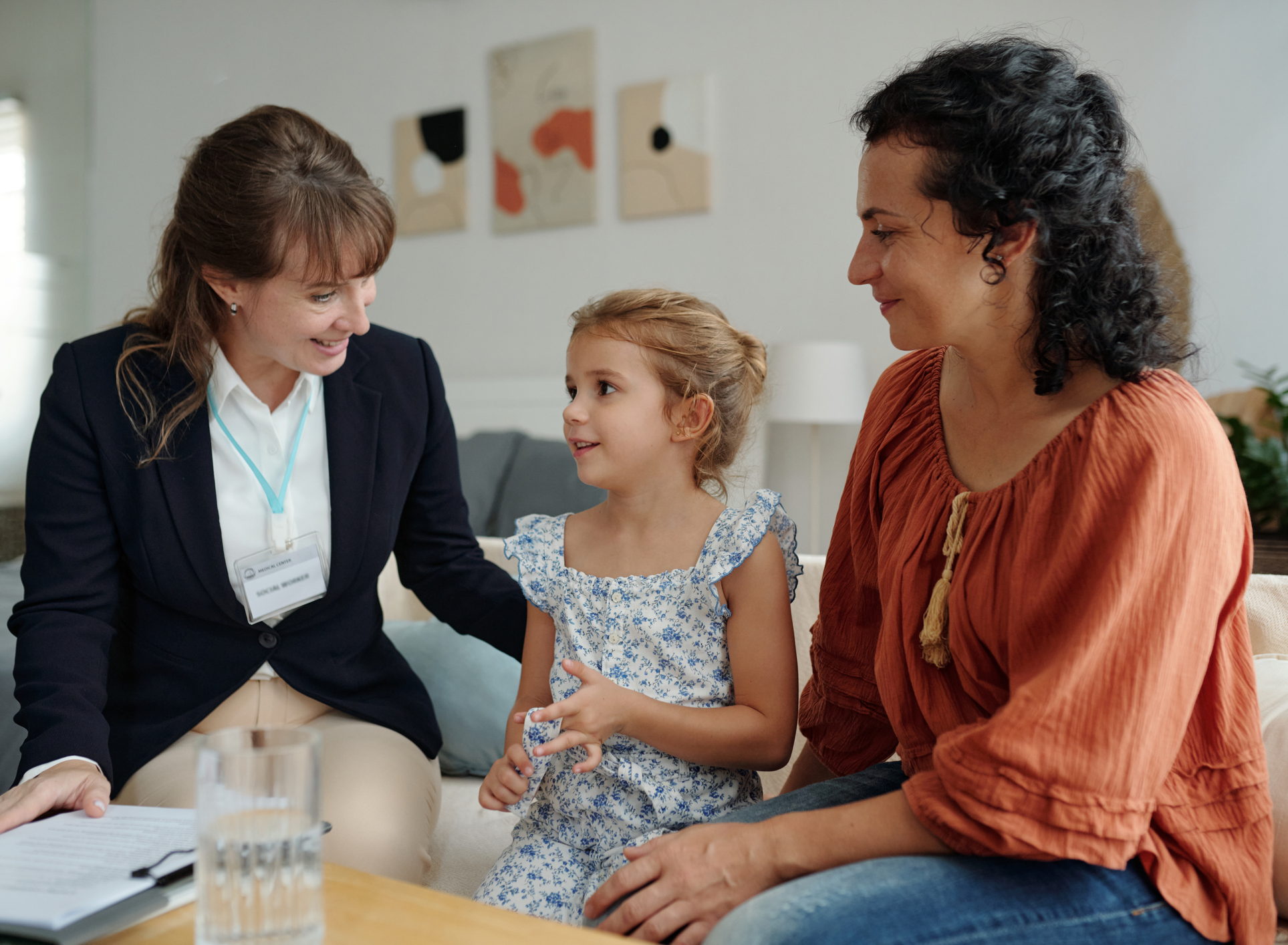 girl smiling with mom and therapist during autism treatment